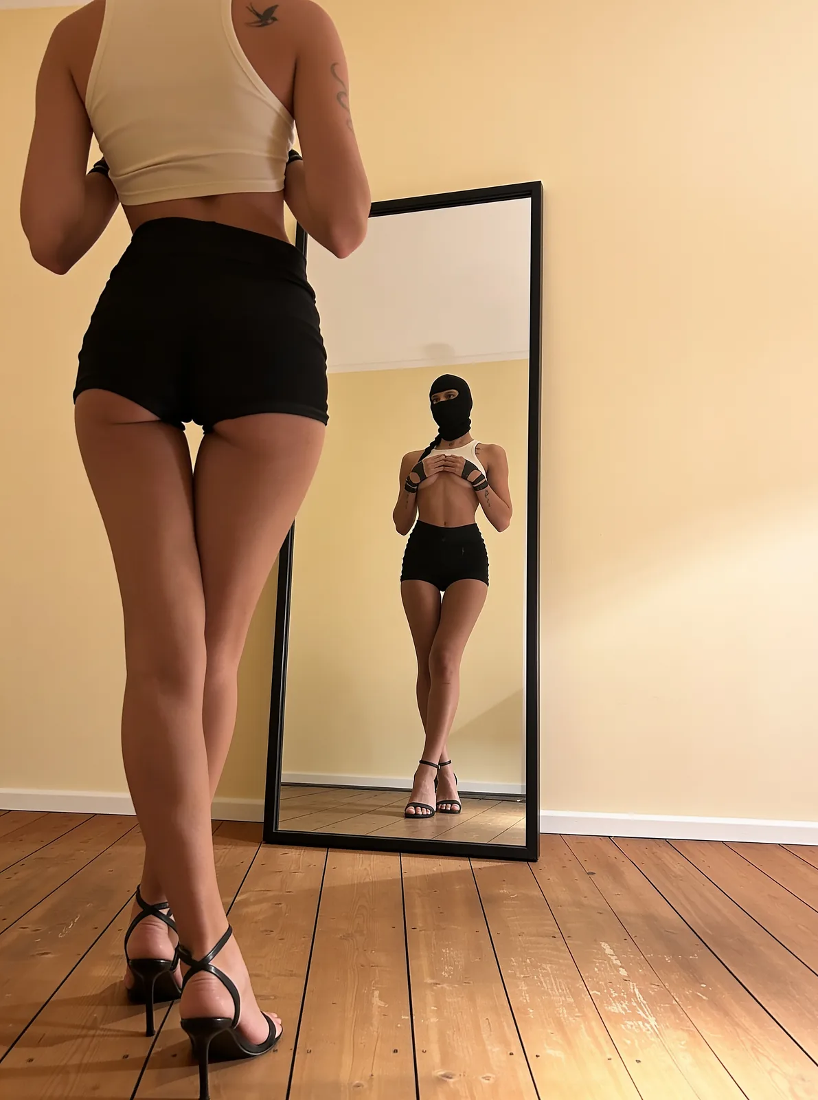 Lady Venom vor dem Standspiegel ihres Studios in Koblenz, lange Beine in High Heels, maskiertes Spiegelbild